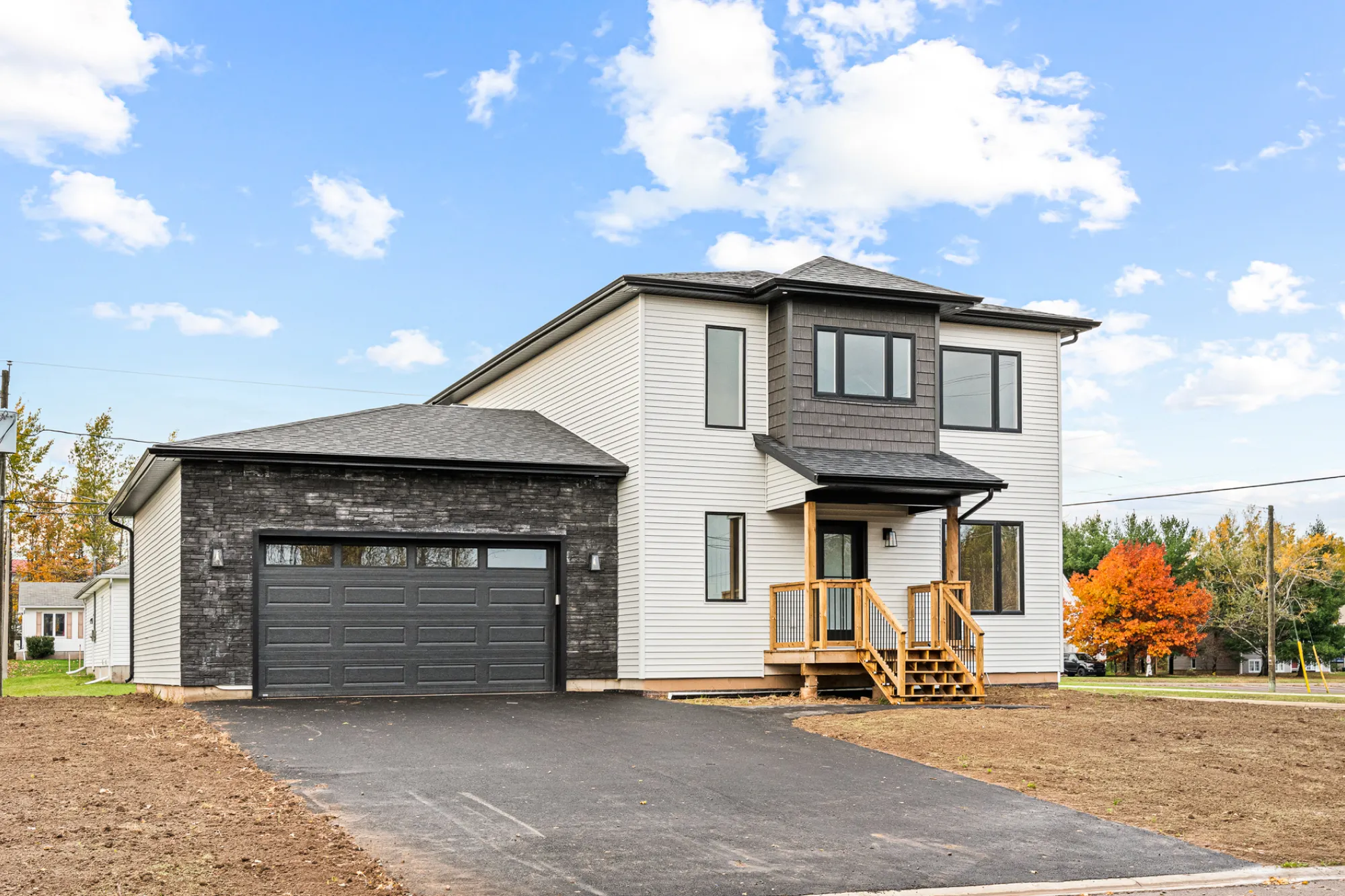 Exterior is a mix of premium vinyl horizontal siding, dark vinyl shake siding, and dark stone around the garage.