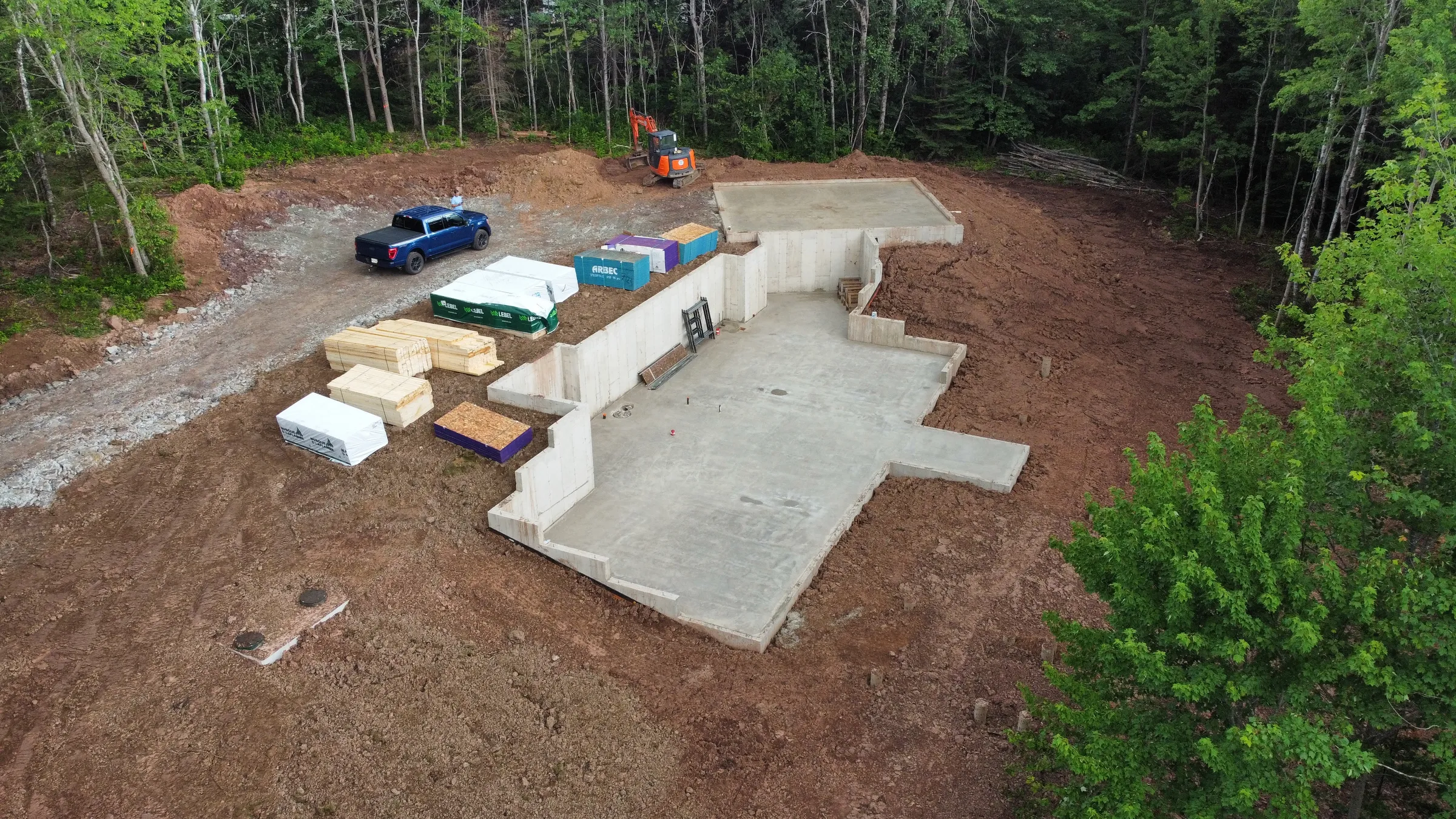 A to be built home with the foundation poured and supplies delivered