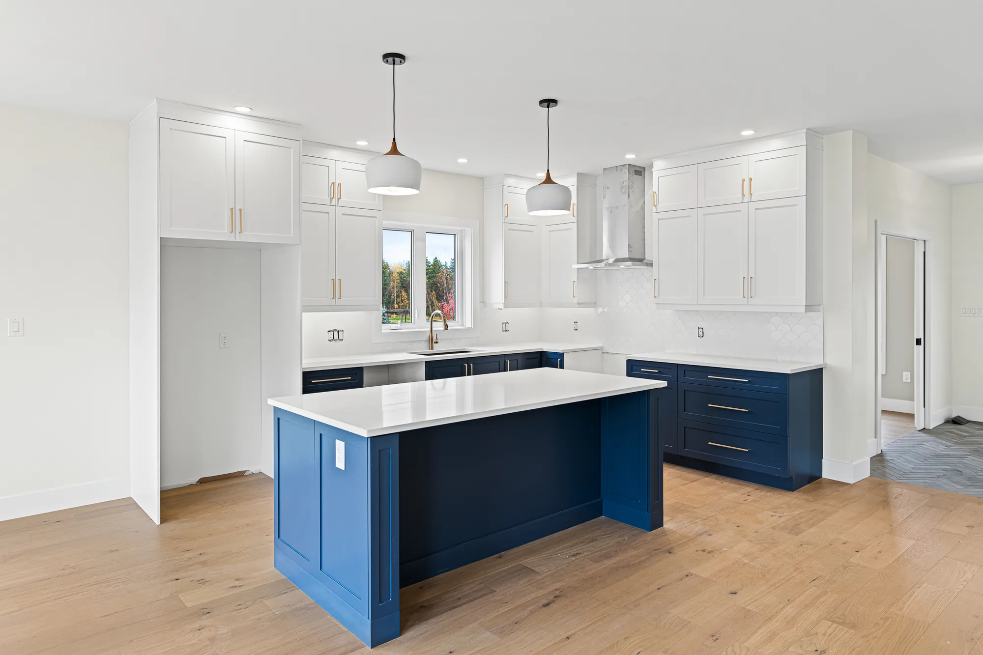 Custom two toned kitchen with gold hardware and finishes, accent this entertainment space beautifully.